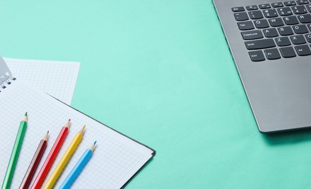 Laptop and notebook with colored pencils