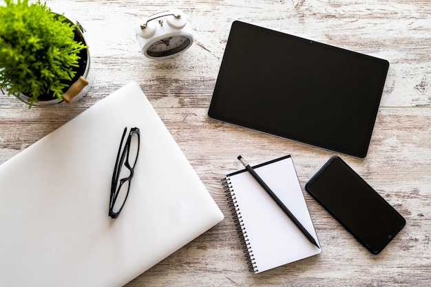 Laptop, Notepad, Tablet And Cell Phone On Work Desk