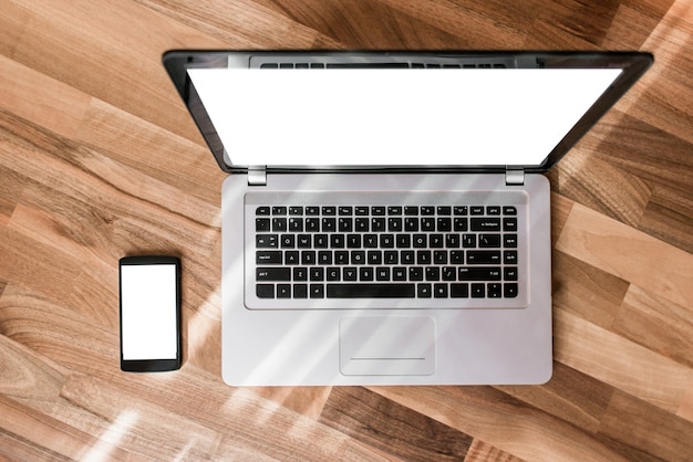 Laptop op een houten tafel met een mobiele telefoon