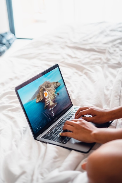 Laptop op leeg bedKaukasische vrouw die op bed ligt met behulp van laptop