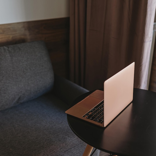 Laptop op tafel bij een comfortabele bank