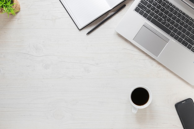 Photo laptop; pencil; diary; cell phone and coffee cup on wooden textured desk