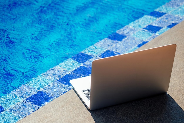 Laptop at the pool, remote work on holiday freelance and frilansing concept