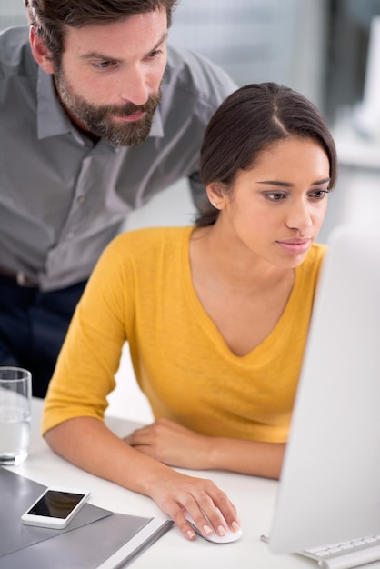 Laptop Reading & Management - オフィスの女性とクリエイティブなプロジェクトをオンラインで研究するキャリアテクノロジーとプロフェッショナルな男性が女性デザイナーの仕事をインターネットでコンピューターで職場で手伝っています