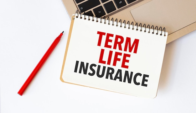 흰색 배경에 TERM LIFE INSURANCE라는 텍스트가 있는 노트북 빨간색 펜 및 메모장