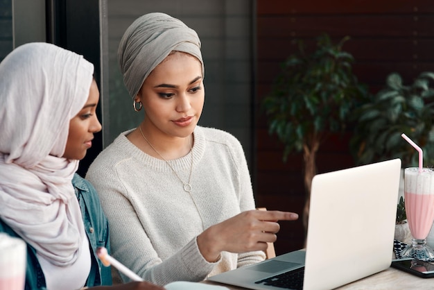 노트북 레스토랑과 이슬람 여성들은 원격 전자 학습 학습 및 팀워크를 위한 계획 및 온라인 교육에 대해 이야기하고 있습니다. 사우디아라비아의 이슬람 사람들 친구나 학생들은 카페에서 컴퓨터를 확인합니다.