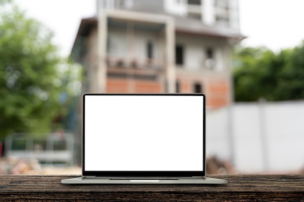 Laptop screen blank white Blur the background of the ongoing construction of a house Architect concept