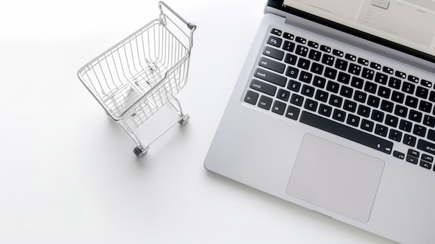 A laptop next to a shopping cart on a white table