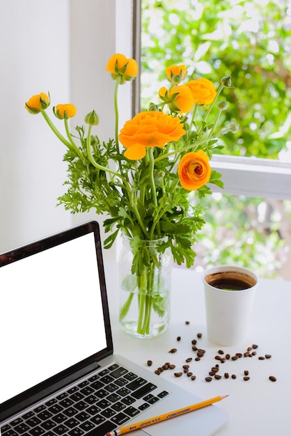 Photo a laptop sits next to a vase of flowers and a cup of coffee mockup