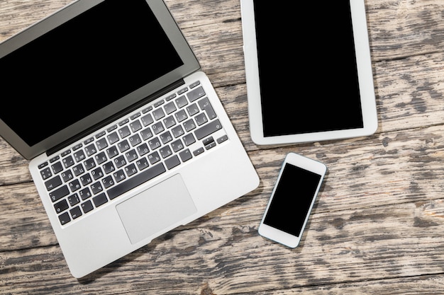 Photo laptop, smartphone and digital tablet on wooden background