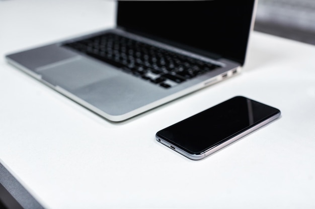 Laptop and smartphone on the office desk table