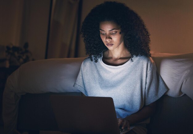laptop sofa and woman typing at night for website online social media and internet in home living room computer and remote work freelance and person writing on technology with insomnia in house