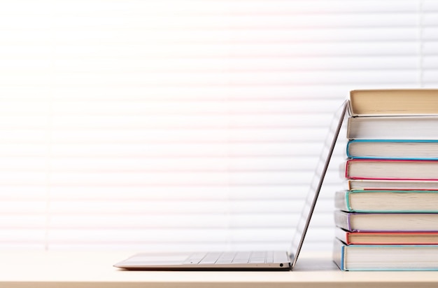 Laptop and stack of books on desk