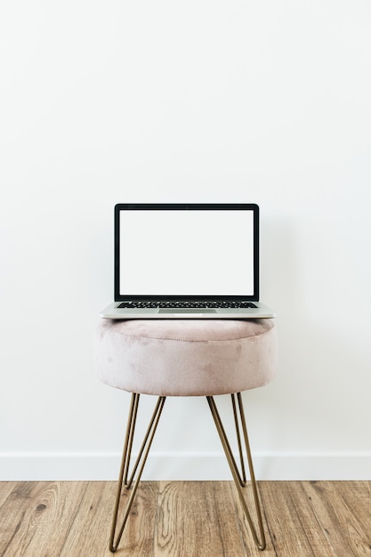 Laptop on stool. Copy space template on white