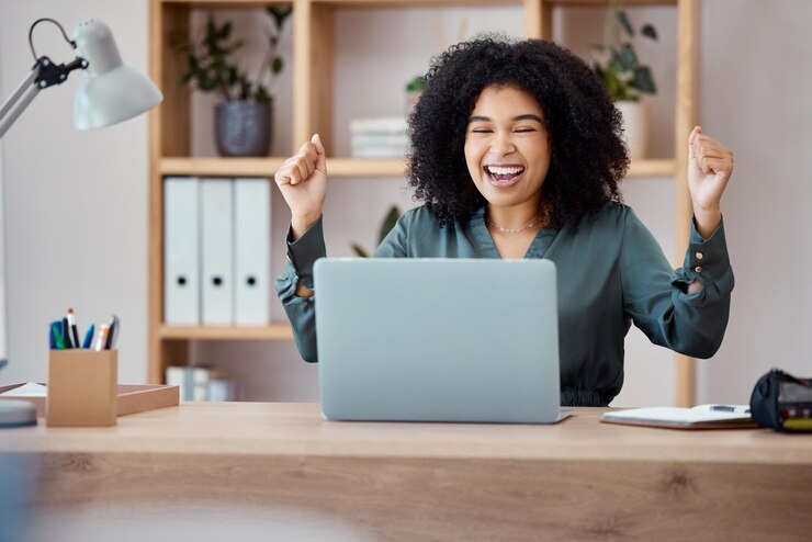 Photo laptop success and business woman in celebration at her desk in modern corporate office happy celebrate and professional employee from mexico with promotion successful project or goal achievement