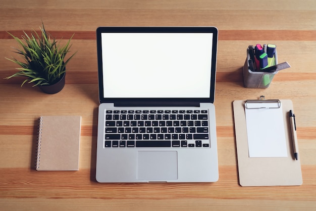 Laptop on table in office room background