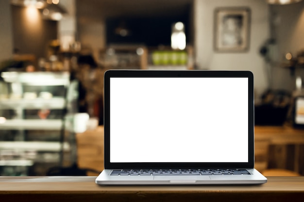 Laptop on the table with coffee shop background.