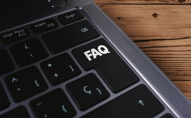 Laptop toetsenbord met FAQ woord op knop. Bedrijfsondersteuningsconcept. Veel gestelde vragen symbool