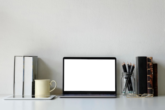 Laptop van het de werkruimtemodel van het bureau, boeken, potlood en koffiemok op bureau.