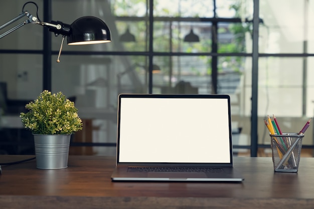 Ноутбук белый экран и лампы с помощью бланка на столе.