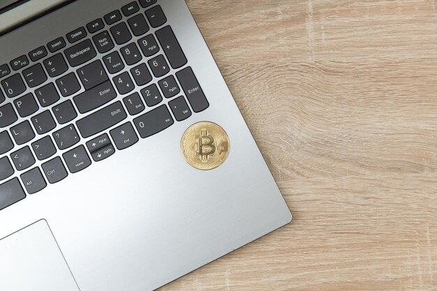 Laptop with bitcoin on a wooden table Top view