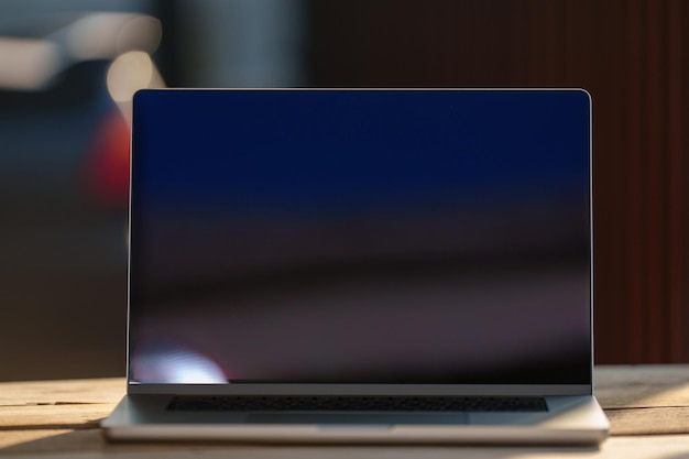 Laptop with black blank screen on a wooden desk