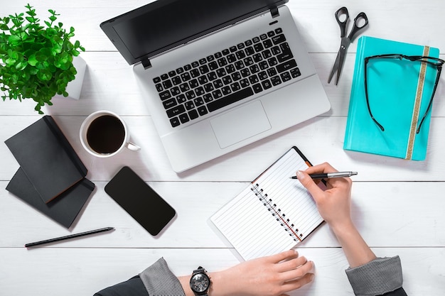 Laptop with blank screen and girl's hands. Flat lay, top view workspace. Copy space