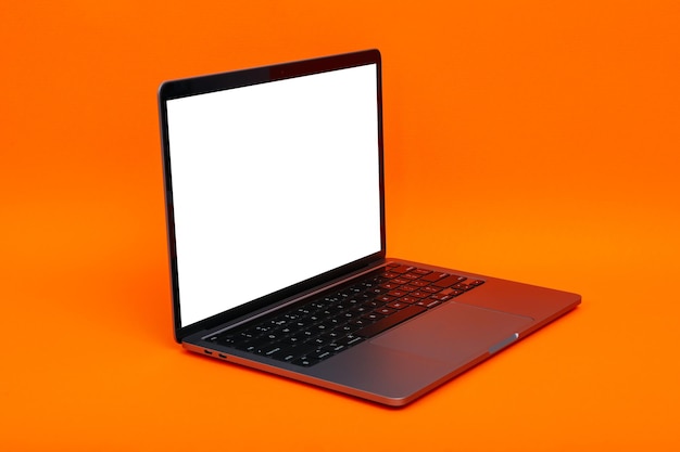 Laptop with blank screen on orange background