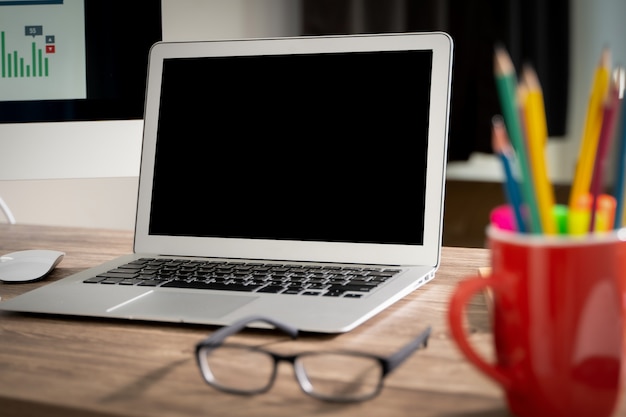 Laptop with blank screen on table.