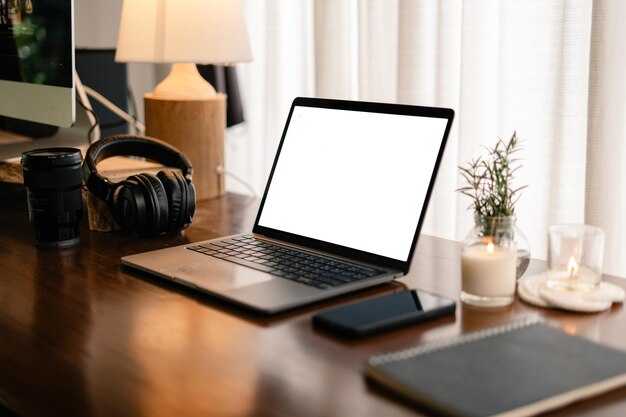 Laptop with blank screen on wooden table in home