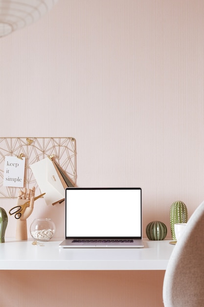 Laptop with blank white screen on office desk interior. Stylish gold workplace mockup table view.