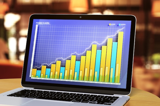 Laptop with business graph on a wooden table