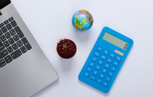 Laptop with cactus, calculator, globe on a white. Minimalistic workspace