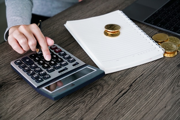 Laptop with calculator and golden bitcoin. Cryptocurrency investors concept.