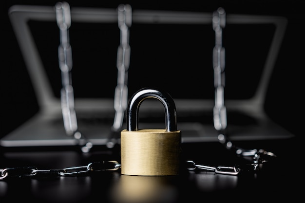 Laptop with chains and lock on black isolated