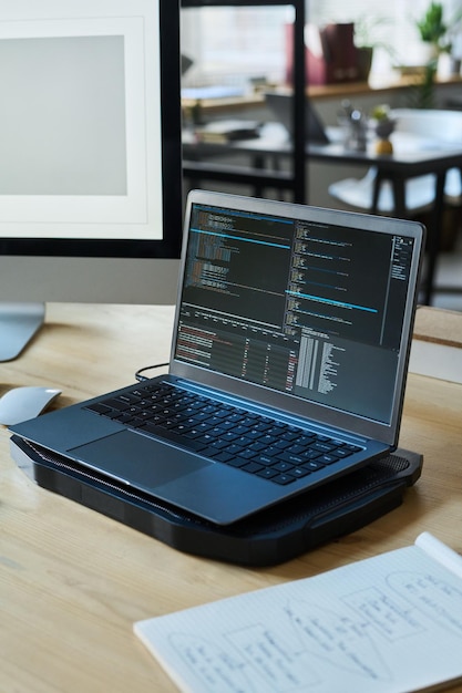 laptop with coded data on workplace