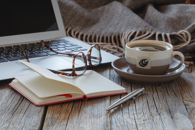 Ноутбук с чашкой кофе домашнего офиса.