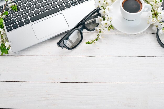 Laptop with coffee and flowers Business On a wooden background Top view Copy space