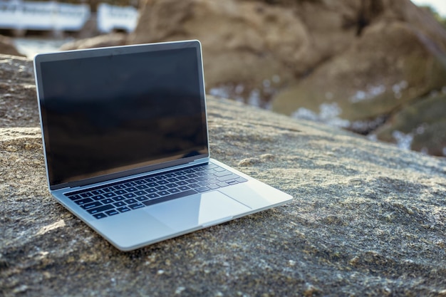 Laptop with dark screen on the rock