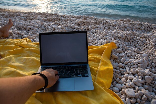 Laptop with empty screen at sea beach freelance concept\
remotely work