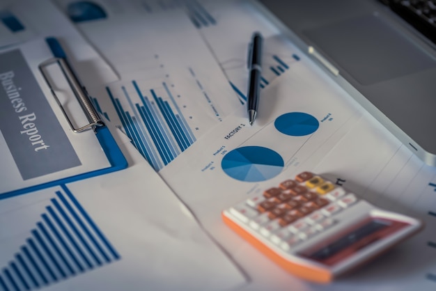 Laptop with financial documents on wooden table