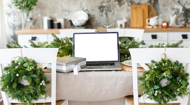 laptop with gift box and christmas lights background.