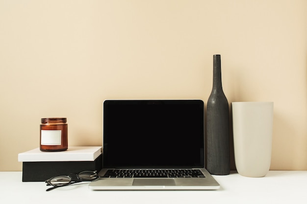 Laptop with mockup blank copy space screen on table. Office desk workspace with decorations.