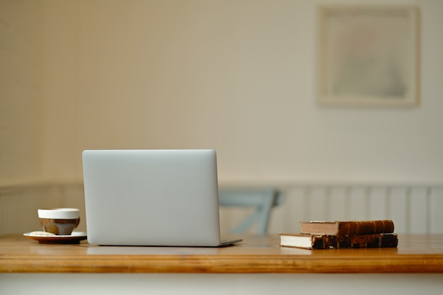 Laptop with office supplies and gadgets on wooden table