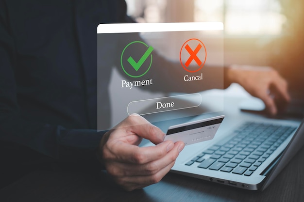 オンライン決済ハンドタッチバンキングオンライン請求書支払いを備えたラップトップビジネステクノロジー仮想画面の背景に承認されたコンセプトボタンクレジットカードとネットワーク接続アイコン
