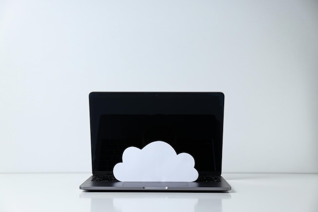 Laptop with a paper cloud on the keyboard on a light background