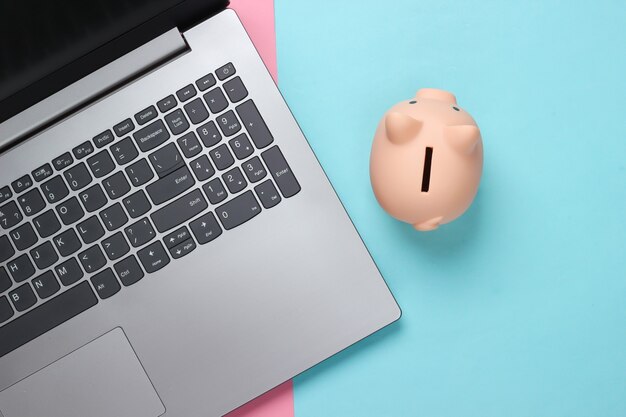 Laptop with Piggy bank on pink blue pastel