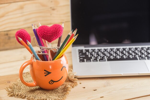 Laptop with smiley wrinkle happy face mug for idea digital artist concept.