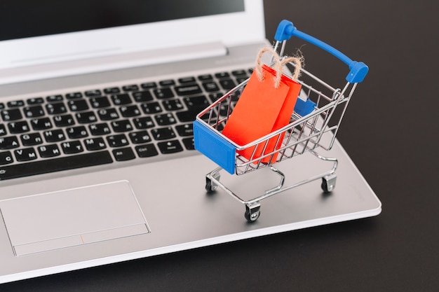 Laptop with toy supermarket cart and packet