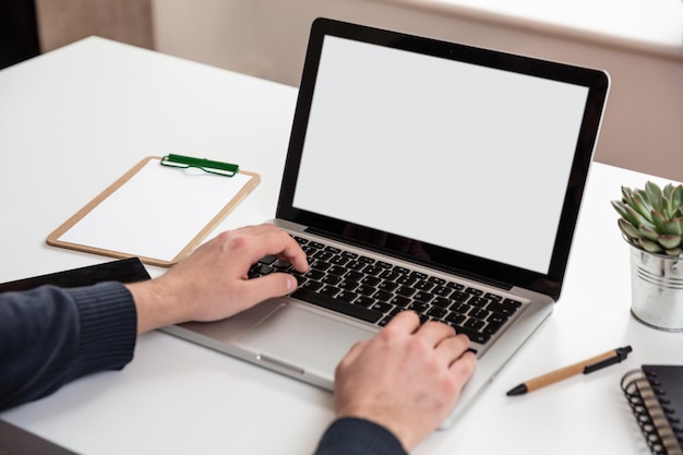 Laptop with white blank screen on a wooden desk